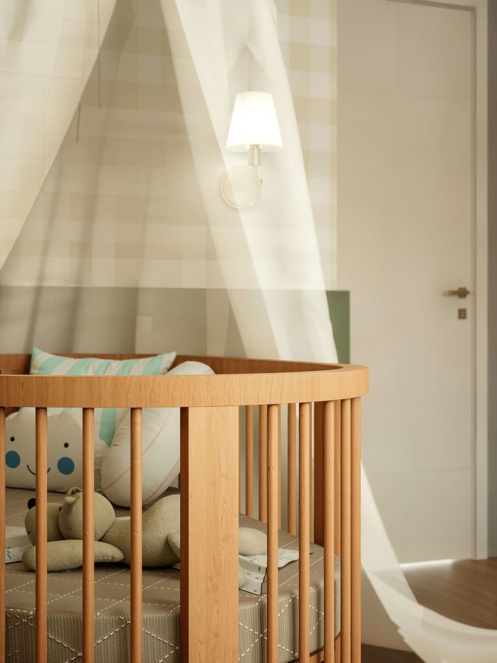 A warm wooden nursery with a round spindle crib